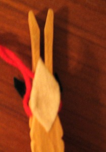 The reindeer's tail and the red yarn for hanging it on the tree.